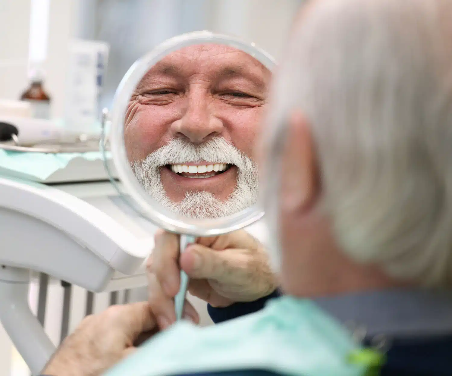 Senior patient smiling during a dental bridge consultation