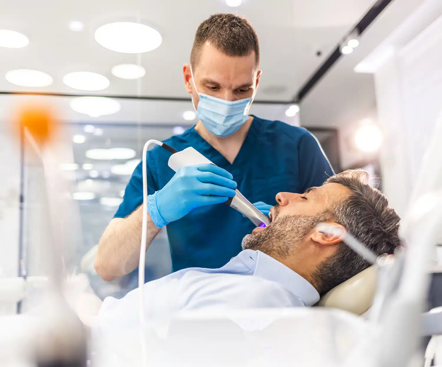 Patient receiving a routine teeth cleaning from a dental hygienist
