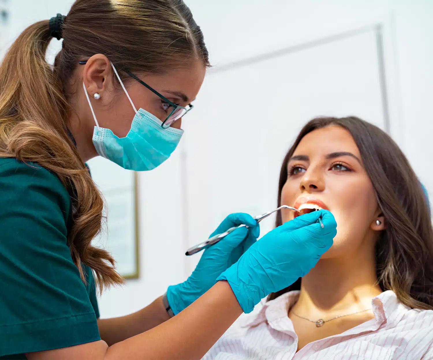 Smile Makeover - Dentist looking at female patient mouth