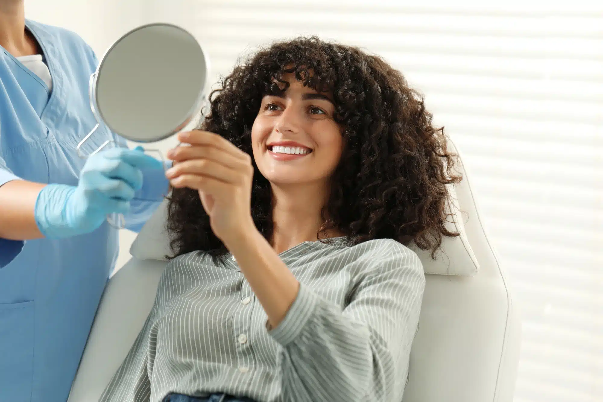 happy woman with her porcelain veneers in Novi, MI