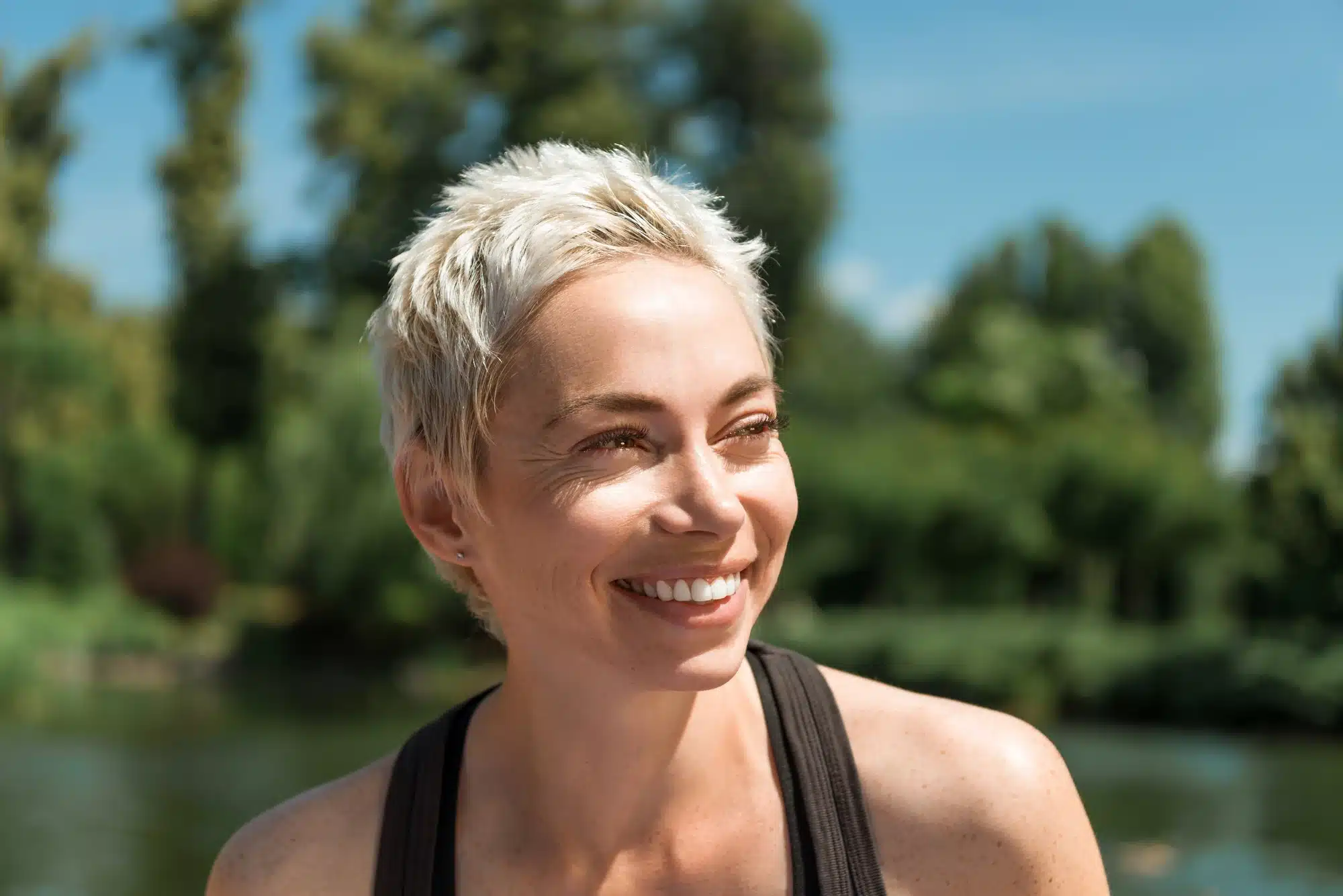 smiling woman after getting dental implants in Novi